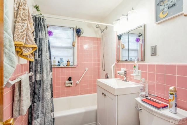 full bath featuring toilet, vanity, tile walls, and shower / tub combo with curtain