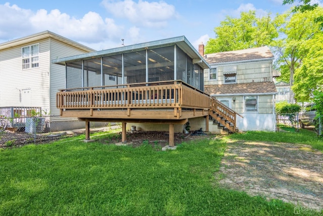 rear view of house featuring a yard, a chimney, a sunroom, fence, and stairs