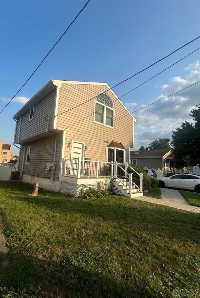 view of home's exterior with a deck and a lawn