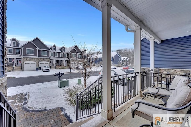 snow covered back of property with a porch