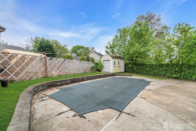 view of swimming pool featuring a storage shed, a fenced backyard, an outdoor structure, and a patio