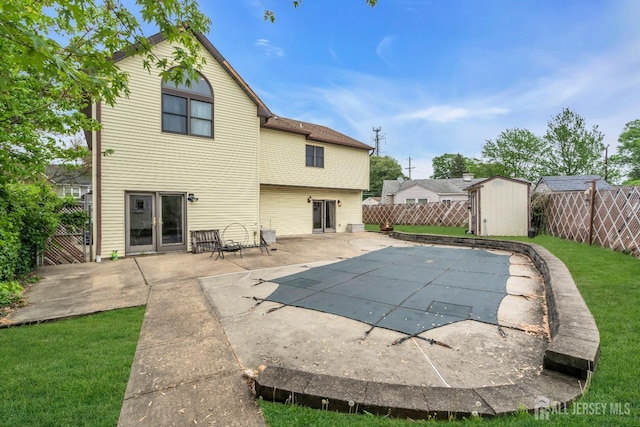 back of property featuring a shed, a patio, and an outdoor structure