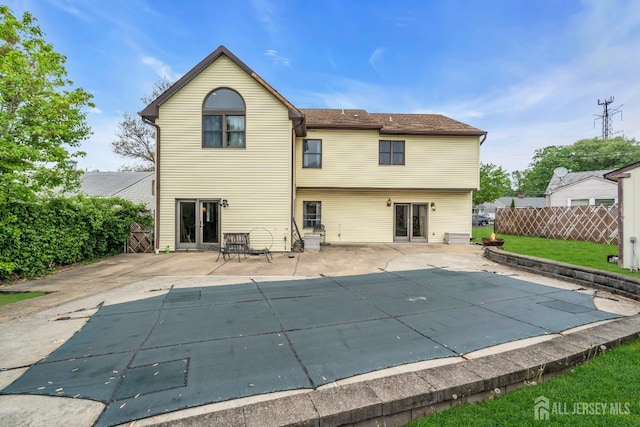 back of property with fence and a patio area