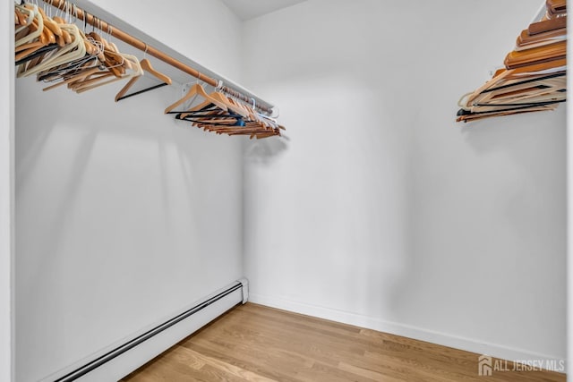 spacious closet with baseboard heating and light wood-style flooring