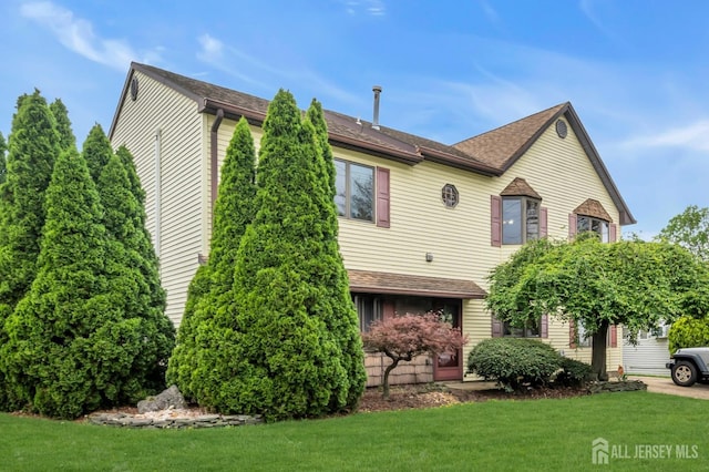 view of front of property with a front yard and a shingled roof