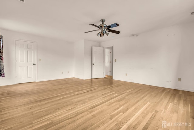 spare room featuring light wood-style floors, ceiling fan, and baseboards