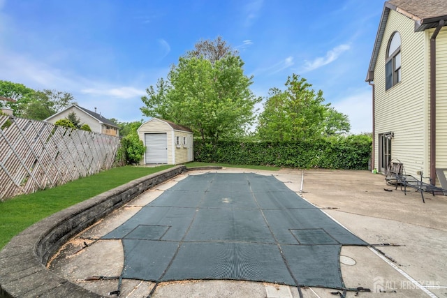 view of swimming pool featuring a patio, a fenced backyard, an outdoor structure, and a storage shed