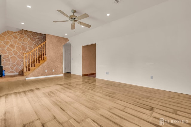 unfurnished living room with stairs, a ceiling fan, vaulted ceiling, recessed lighting, and wood finished floors