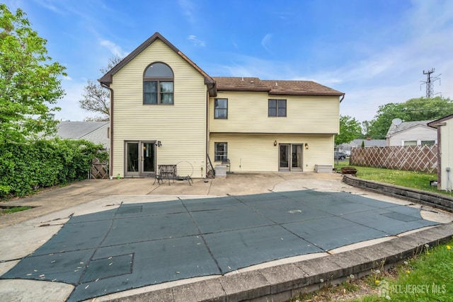 rear view of house with fence and a patio area