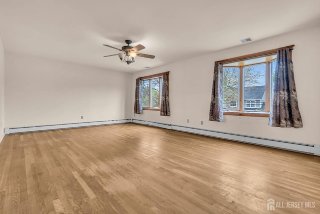empty room featuring a baseboard heating unit, wood finished floors, and a ceiling fan