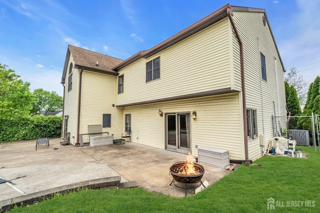 rear view of property featuring an outdoor fire pit and a patio