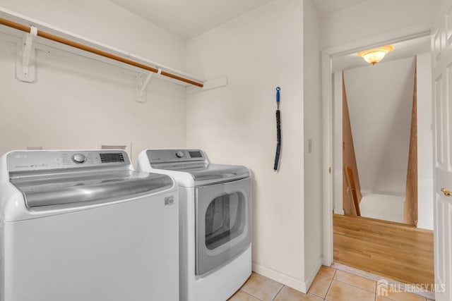 laundry room featuring light tile patterned floors and washer and clothes dryer