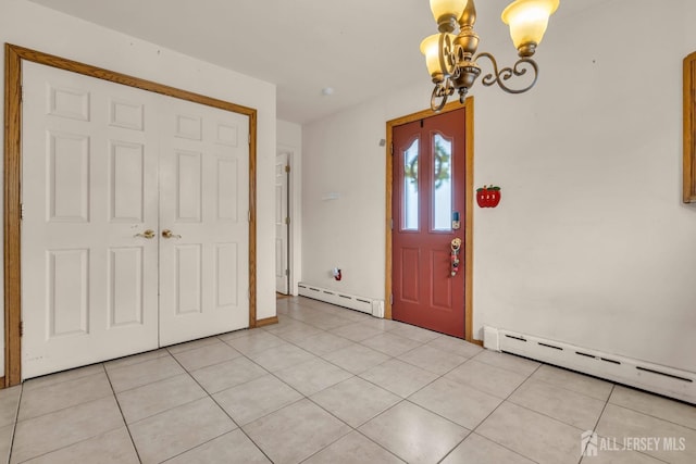foyer with a baseboard radiator, a chandelier, and light tile patterned floors