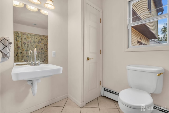 bathroom with baseboard heating, toilet, tile patterned floors, and a sink