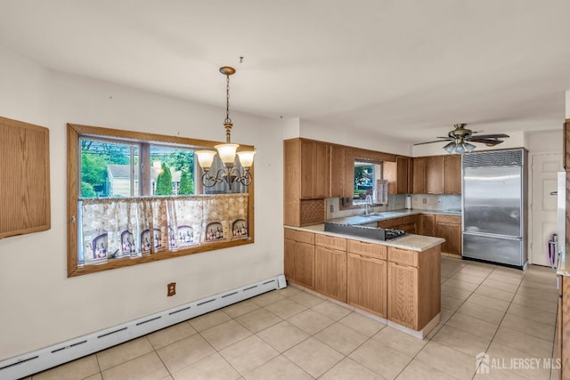 kitchen with stainless steel built in fridge, a baseboard heating unit, a peninsula, a chandelier, and brown cabinetry