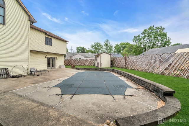 view of swimming pool with a storage shed, a fenced backyard, an outbuilding, and a patio