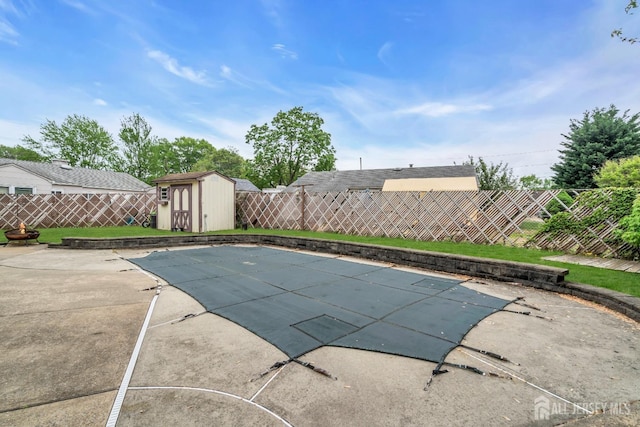 view of swimming pool with a fenced backyard, a storage unit, and a patio
