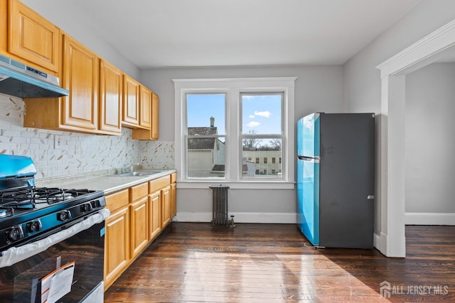 89 Woodbridge Ave, Highland Park, NJ 08904 - kitchen featuring decorative backsplash, stainless steel gas stove, light countertops, freestanding refrigerator, and under cabinet range hood