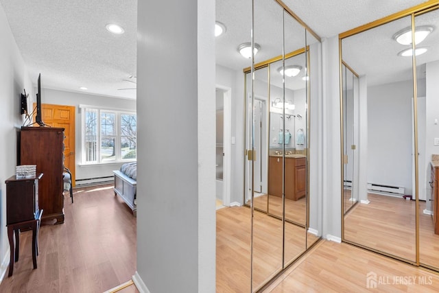 375-C Duranta Plz, Monroe, NJ 08831 - hall featuring a baseboard heating unit, a textured ceiling, baseboard heating, and wood finished floors