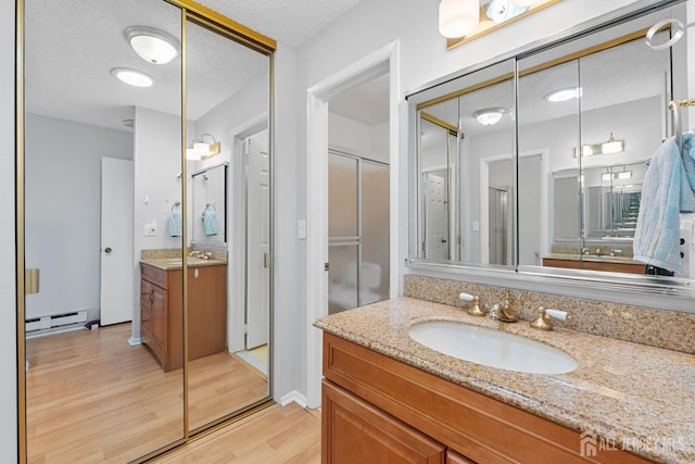 375-C Duranta Plz, Monroe, NJ 08831 - full bathroom featuring a baseboard heating unit, wood finished floors, vanity, and a textured ceiling