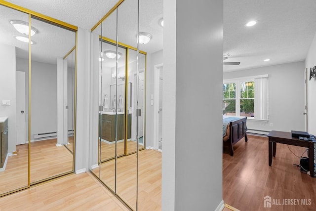 375-C Duranta Plz, Monroe, NJ 08831 - corridor with a baseboard radiator, wood finished floors, a textured ceiling, recessed lighting, and baseboards