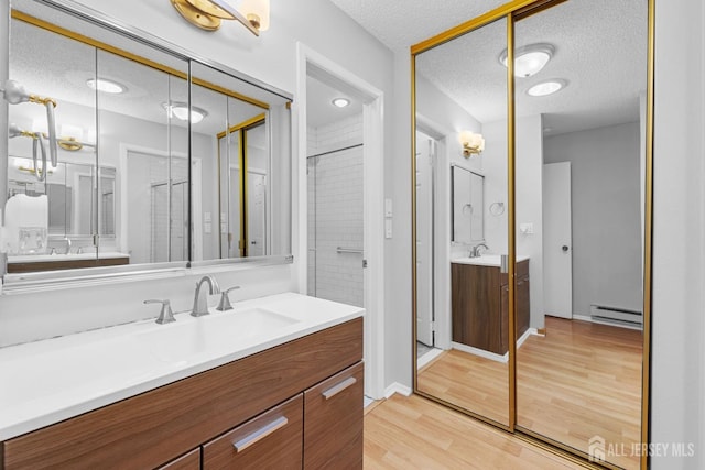 375-C Duranta Plz, Monroe, NJ 08831 - bathroom with a baseboard radiator, a textured ceiling, vanity, wood finished floors, and an enclosed shower