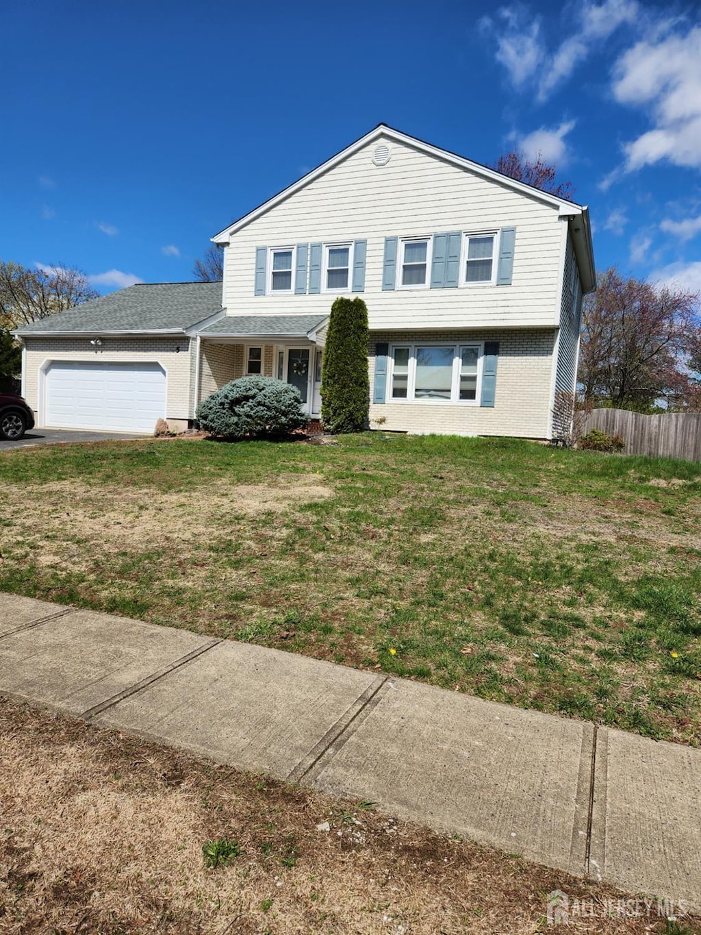 5 Eastern Dr, South Brunswick, NJ 08824 - traditional-style home featuring brick siding, an attached garage, fence, and a front yard