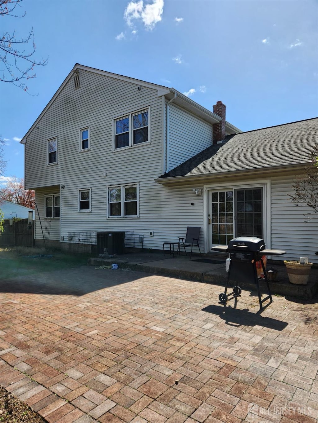 5 Eastern Dr, South Brunswick, NJ 08824 - rear view of house featuring a patio, central AC, and a chimney