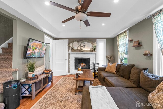 11 Stockton Rd, New Brunswick, NJ 08901 - living area with ceiling fan, a tray ceiling, stairs, wood finished floors, and a fireplace