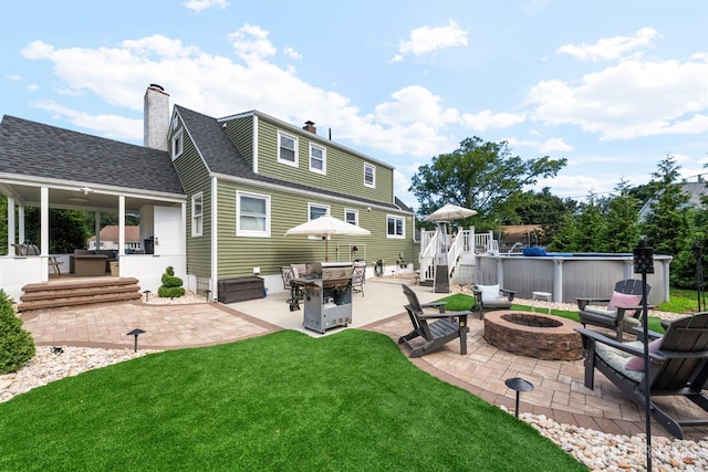 11 Stockton Rd, New Brunswick, NJ 08901 - rear view of property with an outdoor fire pit, a patio area, a chimney, an outdoor pool, and a lawn