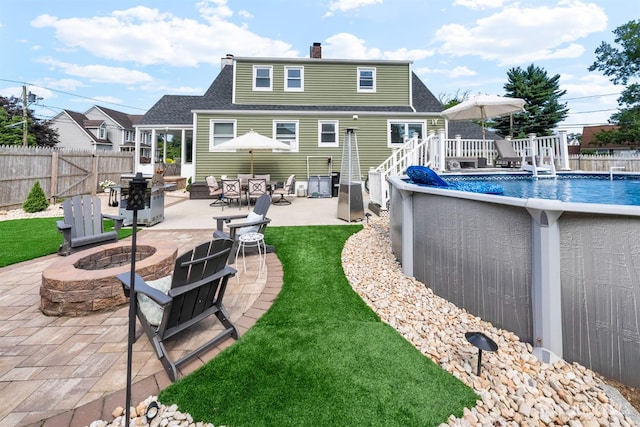 11 Stockton Rd, New Brunswick, NJ 08901 - back of house featuring an outdoor fire pit, a fenced backyard, a chimney, a shingled roof, and a deck