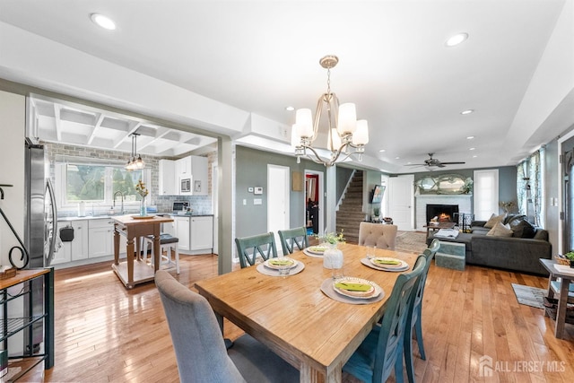 11 Stockton Rd, New Brunswick, NJ 08901 - dining area featuring stairs, a lit fireplace, recessed lighting, light wood finished floors, and a chandelier