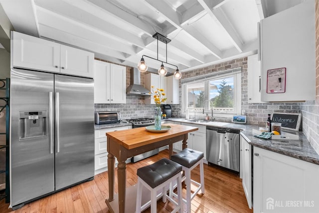 11 Stockton Rd, New Brunswick, NJ 08901 - kitchen with stainless steel appliances, wall chimney range hood, light wood-style floors, white cabinets, and beam ceiling