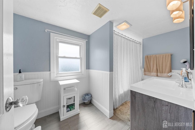 11 Stockton Rd, New Brunswick, NJ 08901 - bathroom with wainscoting, vanity, wood finished floors, and curtained shower