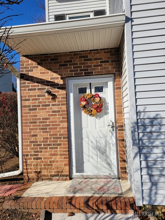 doorway to property with brick siding