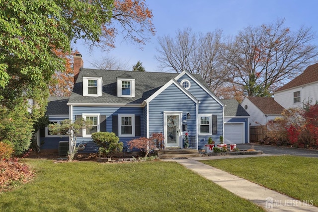 new england style home featuring a front yard and a garage