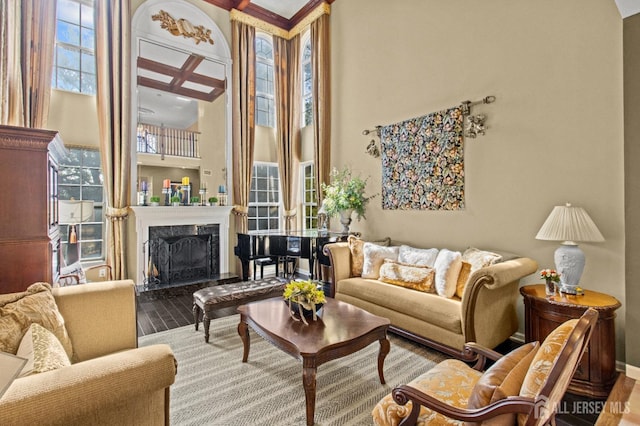 living room featuring a premium fireplace, plenty of natural light, a high ceiling, and hardwood / wood-style flooring