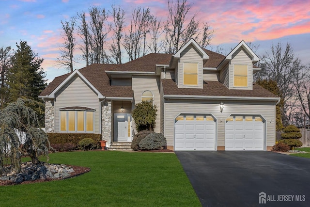 view of front of home featuring driveway, an attached garage, a front yard, and a shingled roof