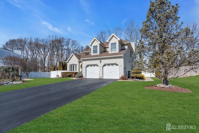 view of front of home featuring a front yard, fence, driveway, an attached garage, and a shingled roof