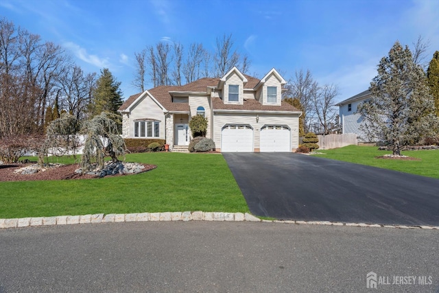 view of front facade with a front yard, an attached garage, driveway, and fence