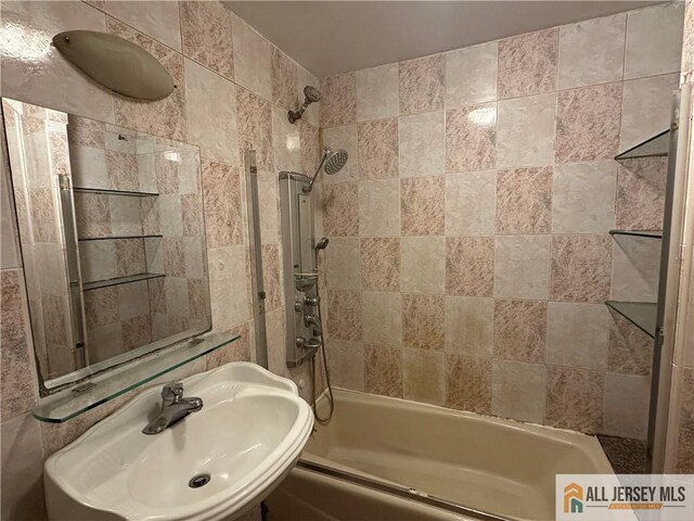 bathroom featuring tiled shower / bath combo and sink