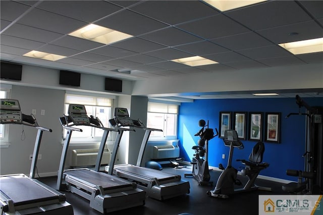 gym with a drop ceiling and a wall mounted AC