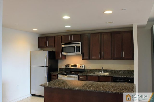 kitchen with dark brown cabinets, sink, appliances with stainless steel finishes, and dark stone counters