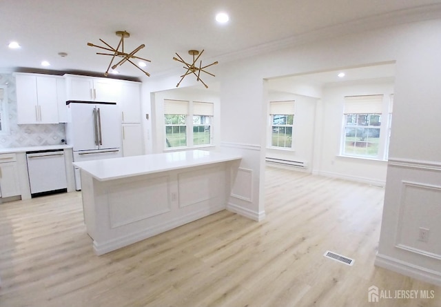 kitchen with white appliances, white cabinetry, an inviting chandelier, light hardwood / wood-style floors, and backsplash