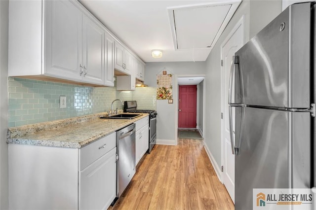 77 Navesink Ave, Middletown, NJ 07748 - kitchen featuring stainless steel appliances, white cabinetry, backsplash, light wood-style floors, and light stone counters