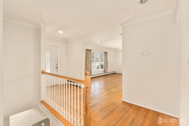 hallway featuring hardwood / wood-style flooring, ornamental molding, and a baseboard heating unit