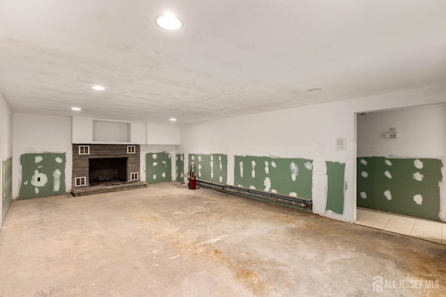 unfurnished living room with concrete flooring and a baseboard heating unit