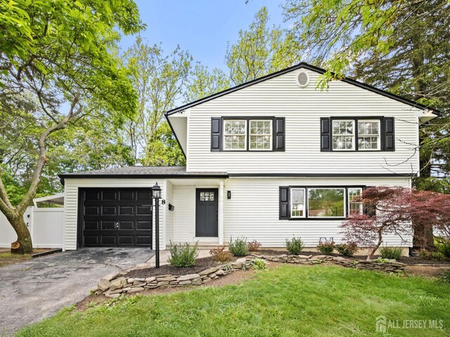 8 S Surrey Ln, East Brunswick, NJ 08816 - view of front of house with asphalt driveway, a garage, and a front yard