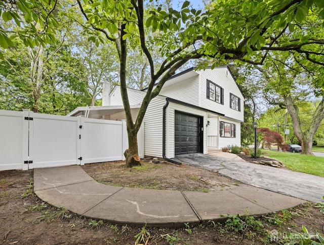 8 S Surrey Ln, East Brunswick, NJ 08816 - view of property exterior featuring a gate, concrete driveway, and an attached garage
