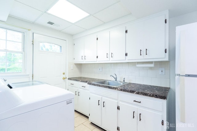 28 Beechwood Ave, Edison, NJ 08837 - kitchen with a sink, freestanding refrigerator, backsplash, white cabinetry, and washing machine and clothes dryer